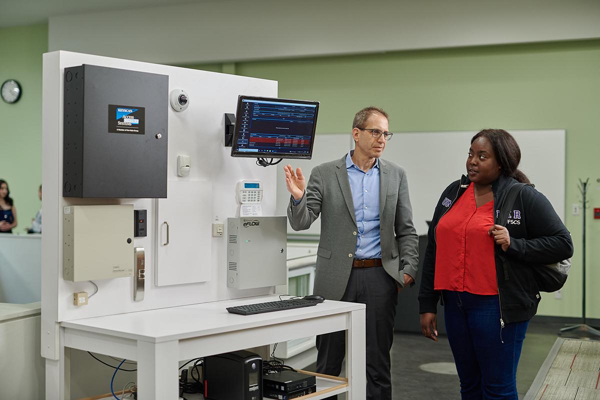 Students who graduated from Humber Polytechnic’s Protection, Security and Investigation program will have a guaranteed offer of full-time employment thanks to a partnership agreement with Paragon Security. Two people are speaking while one gestures towards a computer screen.