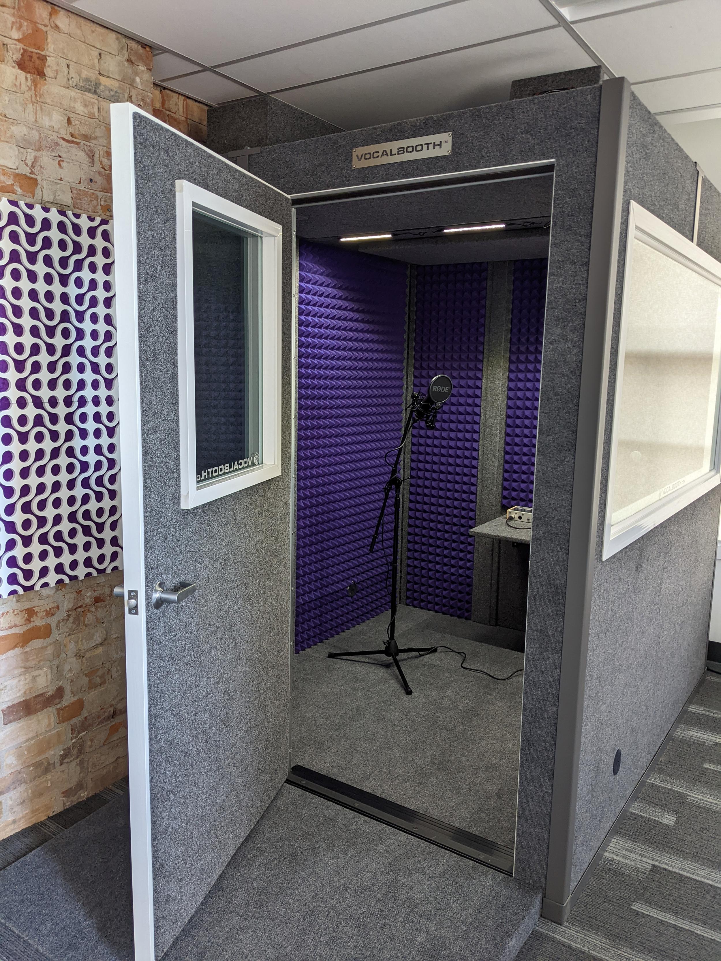 A small recording booth with a microphone.