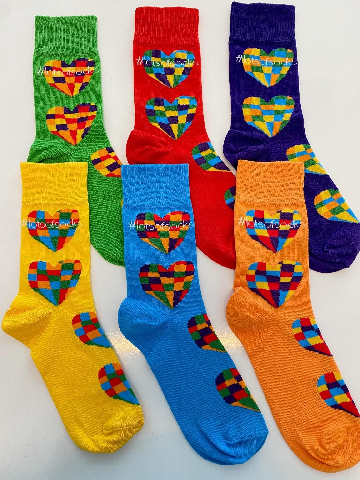 Six pairs of socks with heart designs on them and the words #lotsofsocks.