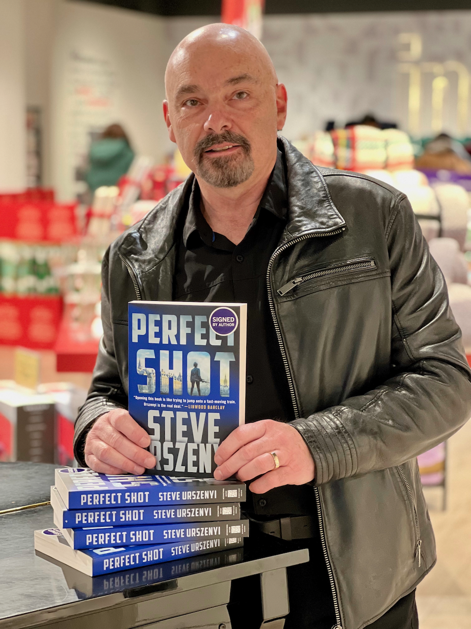 A person holding a book titled Perfect Shot.