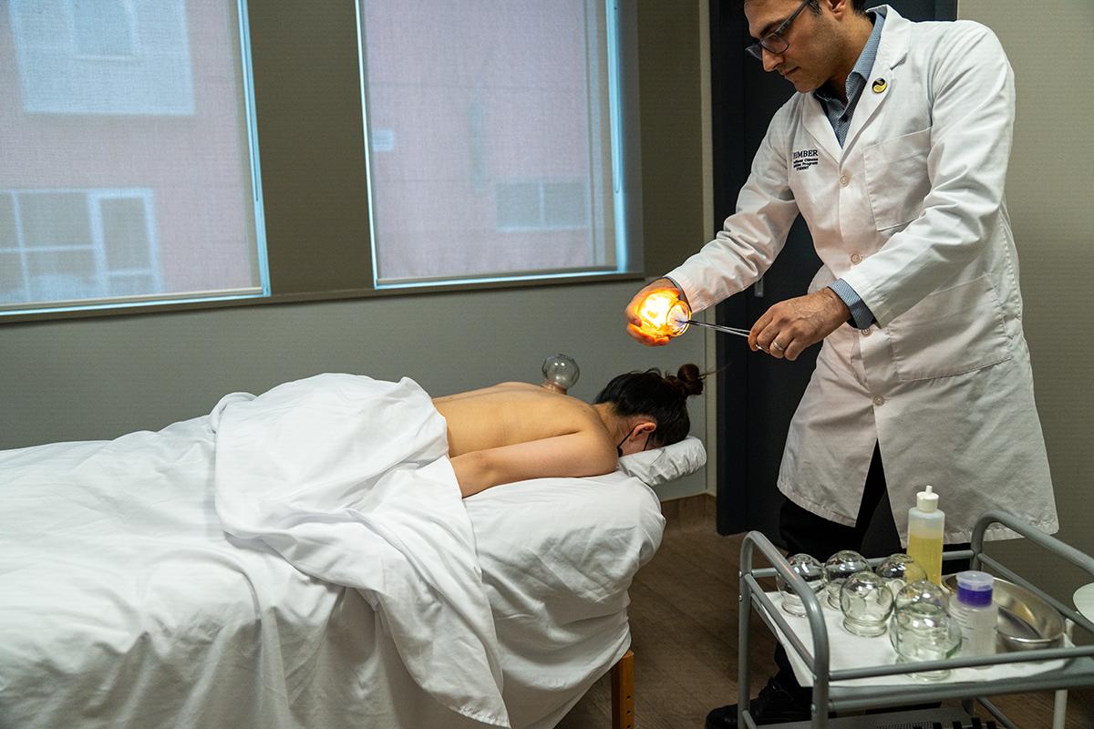 A person is holding a cup and has placed a lit object inside it.