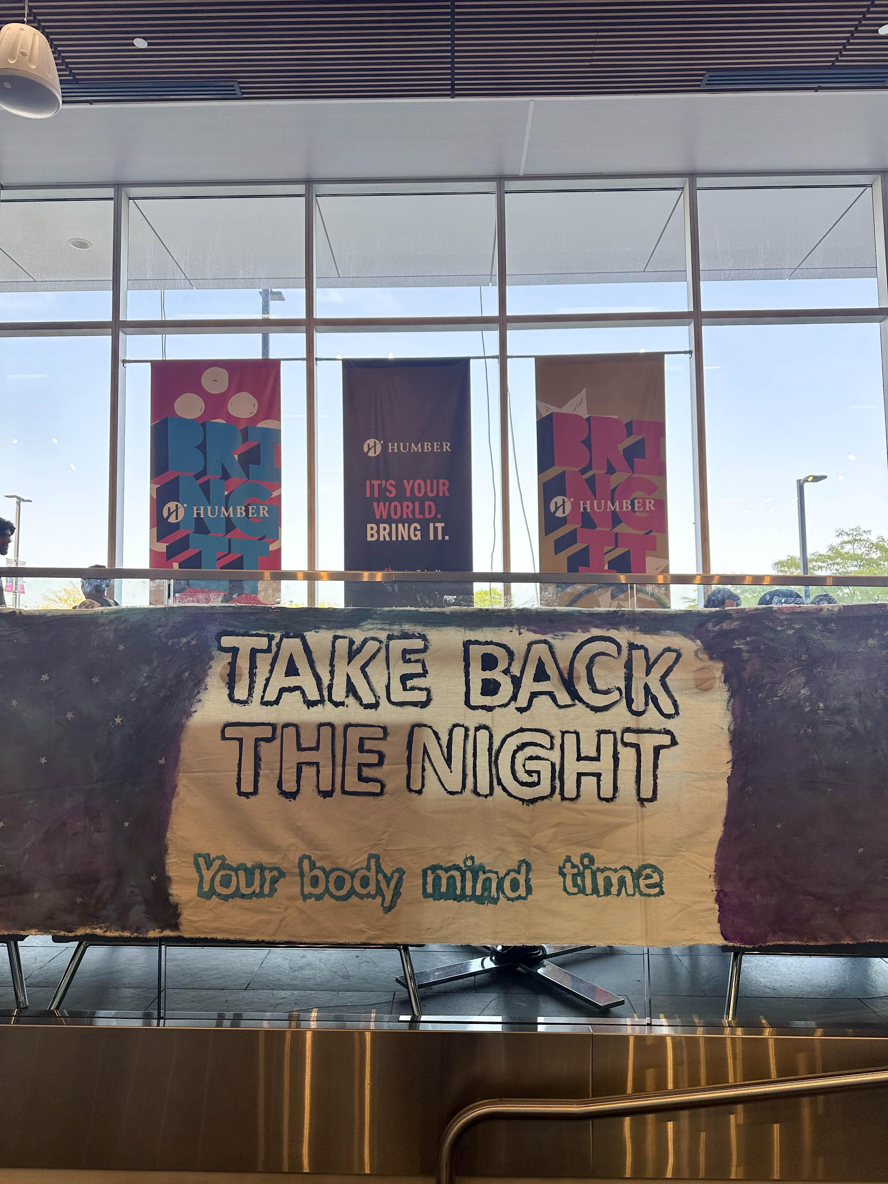 A brown banner that reads Take Back the Night: Your Body Mind Time.