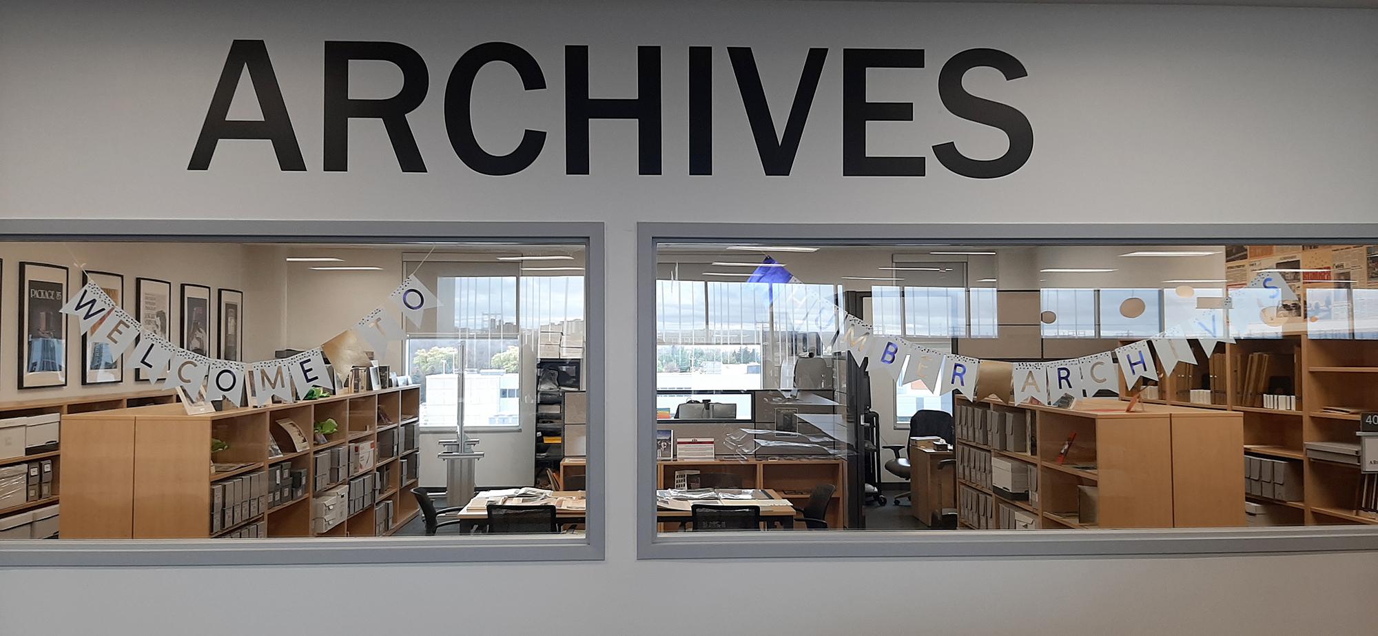 A room filled with books and other material with the word Archives written above it.
