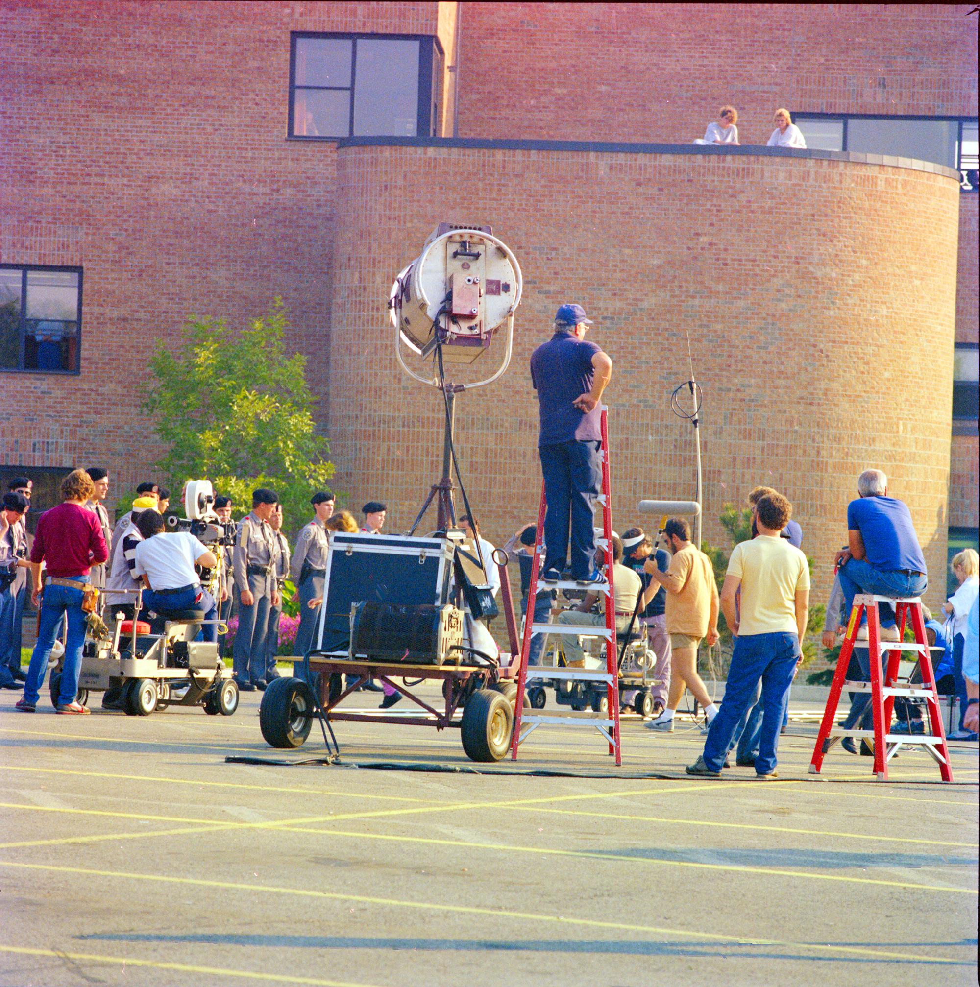 A film crew preparing to film a scene using cameras, lights and other film equipment.
