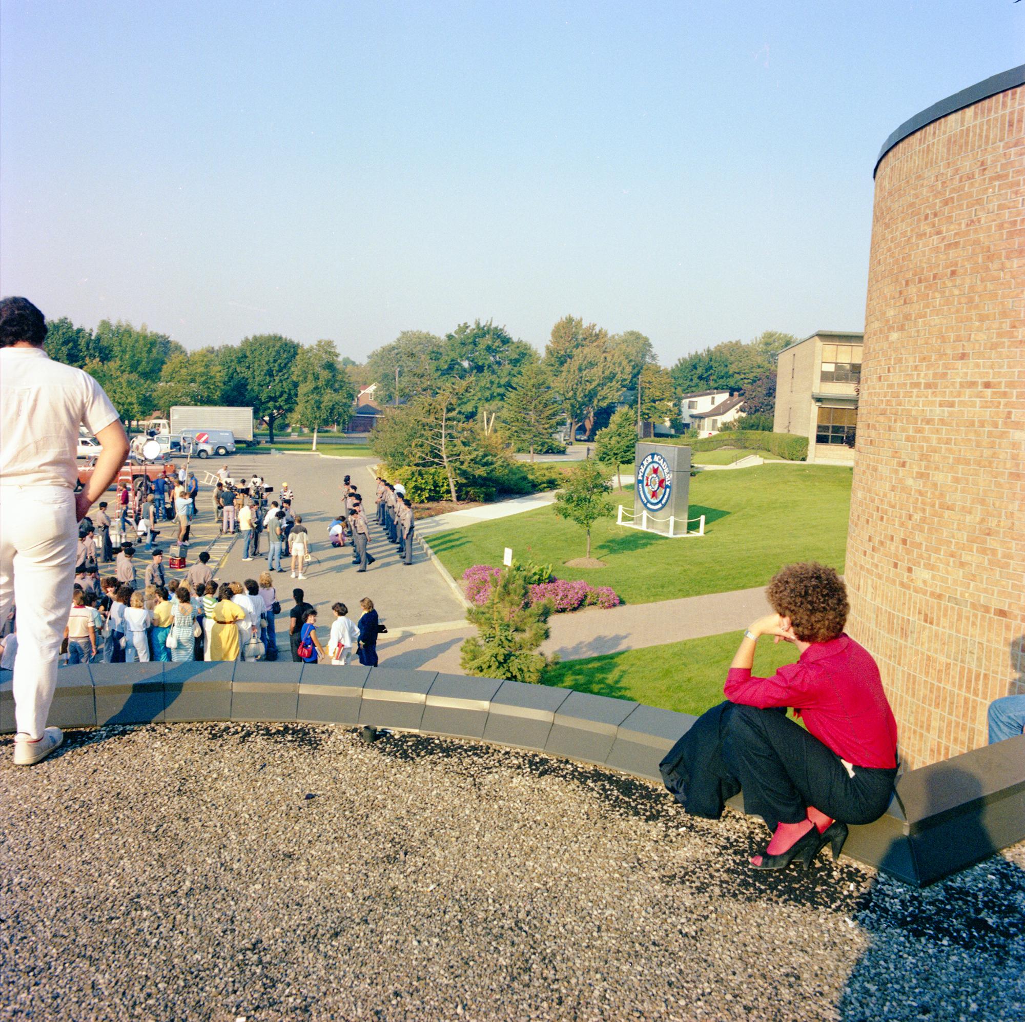 A film crew prepares to film a scene while onlookers watch from a distance.