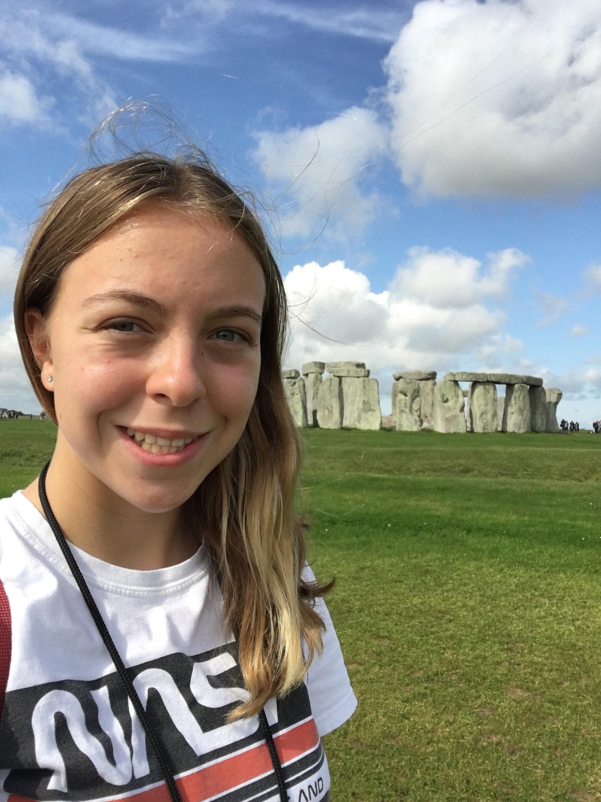 A head-and-shoulders photo of a person. Stonehenge appears in the background.
