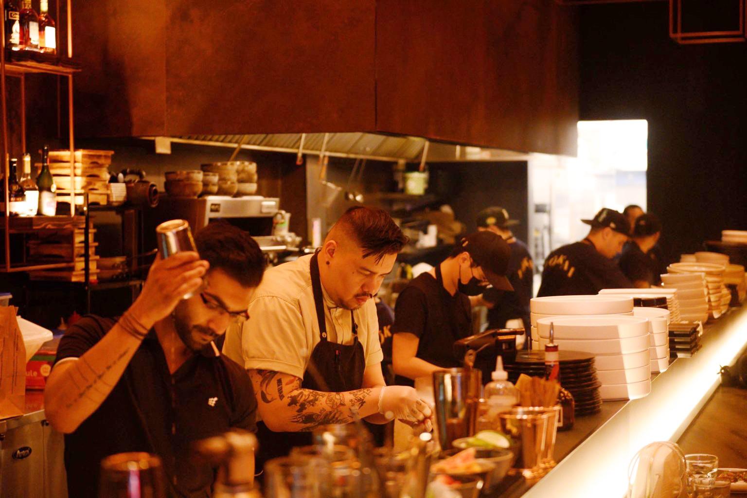 Several chefs cook inside a restaurant’s kitchen.