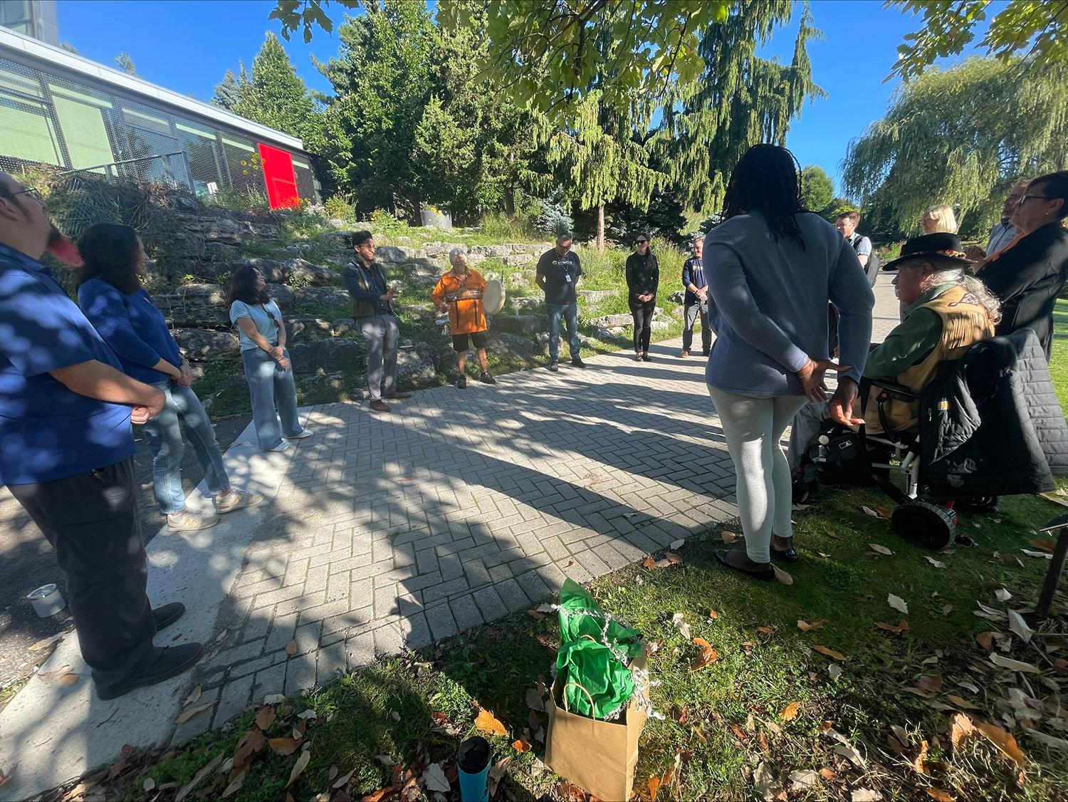 People stand together in a circle outdoors.