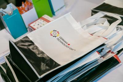A bag with the words German Technology Day written on it is displayed on a table.