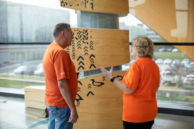 Jason Seright and Ann Marie Vaughan engage in a conversation while wearing orange shirts for Orange Shirt Day.