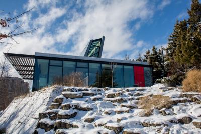 The Humber arboretum sits atop a rocky mound, dusted with snow. Its windowed facade lets the winter sun in.