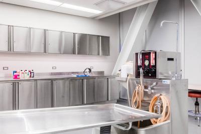 The funeral services lab at Humber's North Campus has stainless steel storage and a stretcher, lit bright in a white room