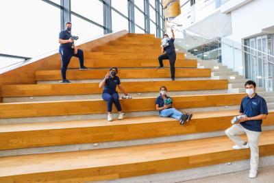 Students sit on the giant yellow staircase in the atrium of the Barrett CTI, distanced by at least 2 metres and wearing masks