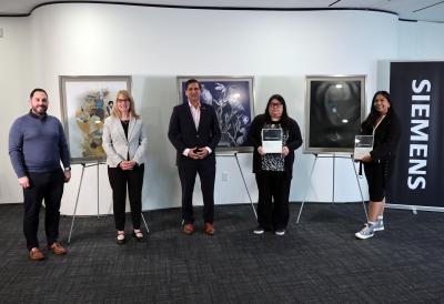 The three winners of the Humber Siemens Art Competition stand in front of their art at Siemens' Canadian headquarters.