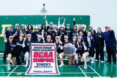 Humber Hawks' women's volleyball team celebrate with their provincial championship banner