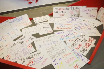 A collection of signs spread out on the floor showing support for Humber’s Take Back the Night event.