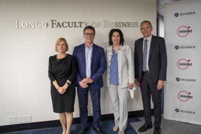 Four people – Alvina Cassiani, Anthony Longo, Rosanne Longo and Chris Whitaker – stand beneath a sign that reads Longo Faculty o