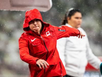 Renee Foessel releases the shot put and follows through in a stadium wearing a Team Canada windbreaker