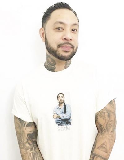 Richard Laurente, a student in the Anti-Black Racism course, stands in front of a white background