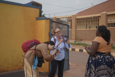 Heather Kelly and Lucy Lau are photographing a woman who is speaking to them and gesturing