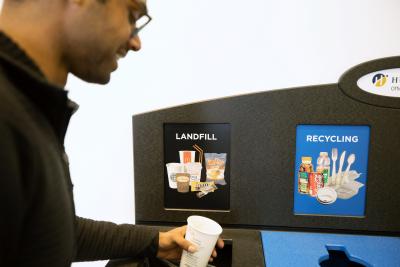 Devon Fernandes tries out the new waste bin at the North campus LRC