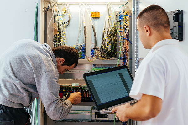 Students working with wiring and a laptop